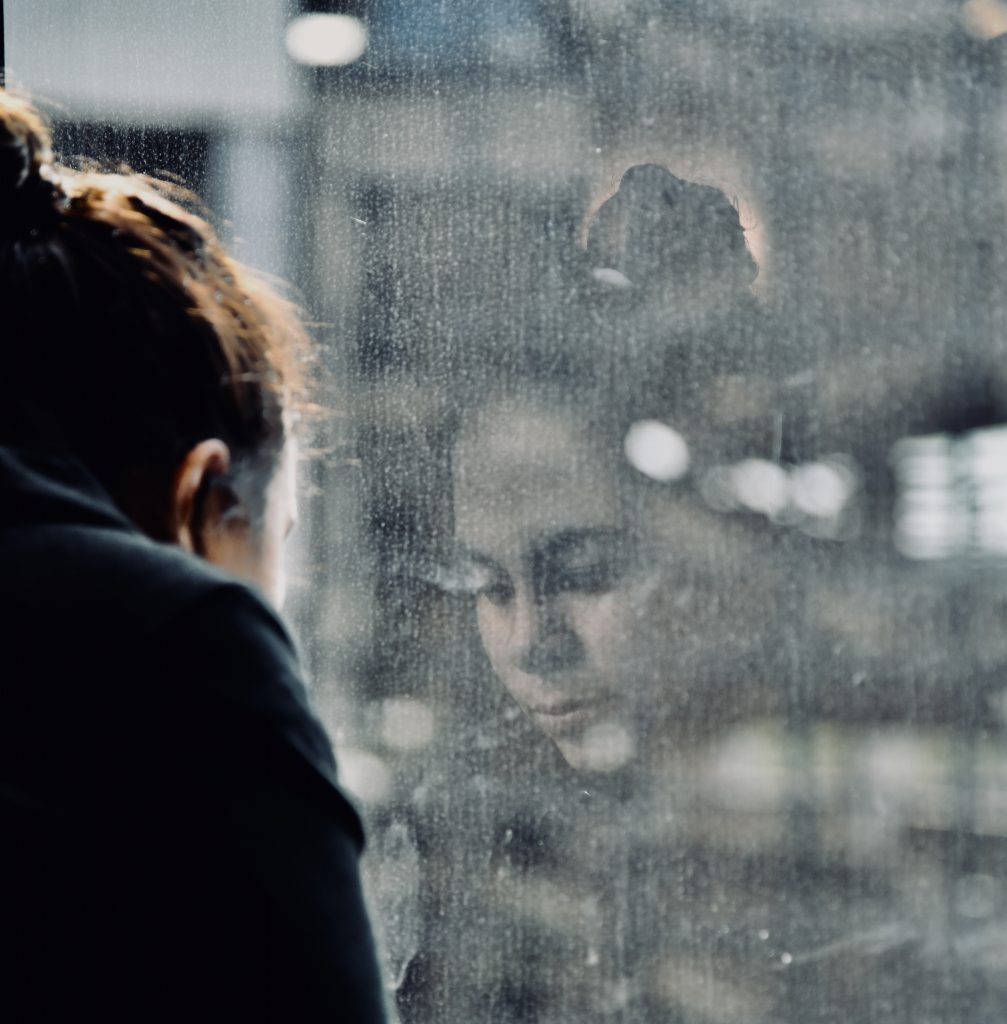 Girl looking at reflection in glass