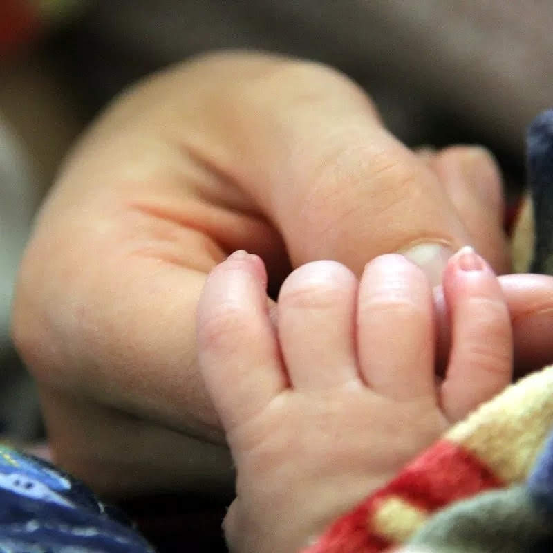 mother and baby holding hands